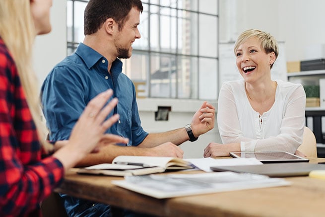 woman in mtg with two others who is laughing