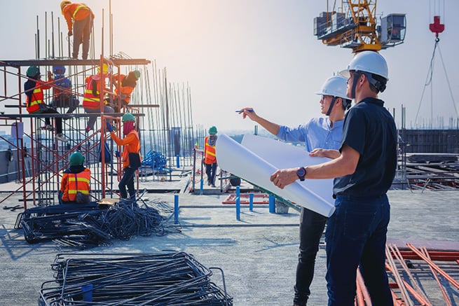 two workers looking at blueprints