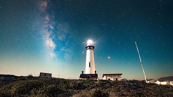 lighthouse shining in the dark sky