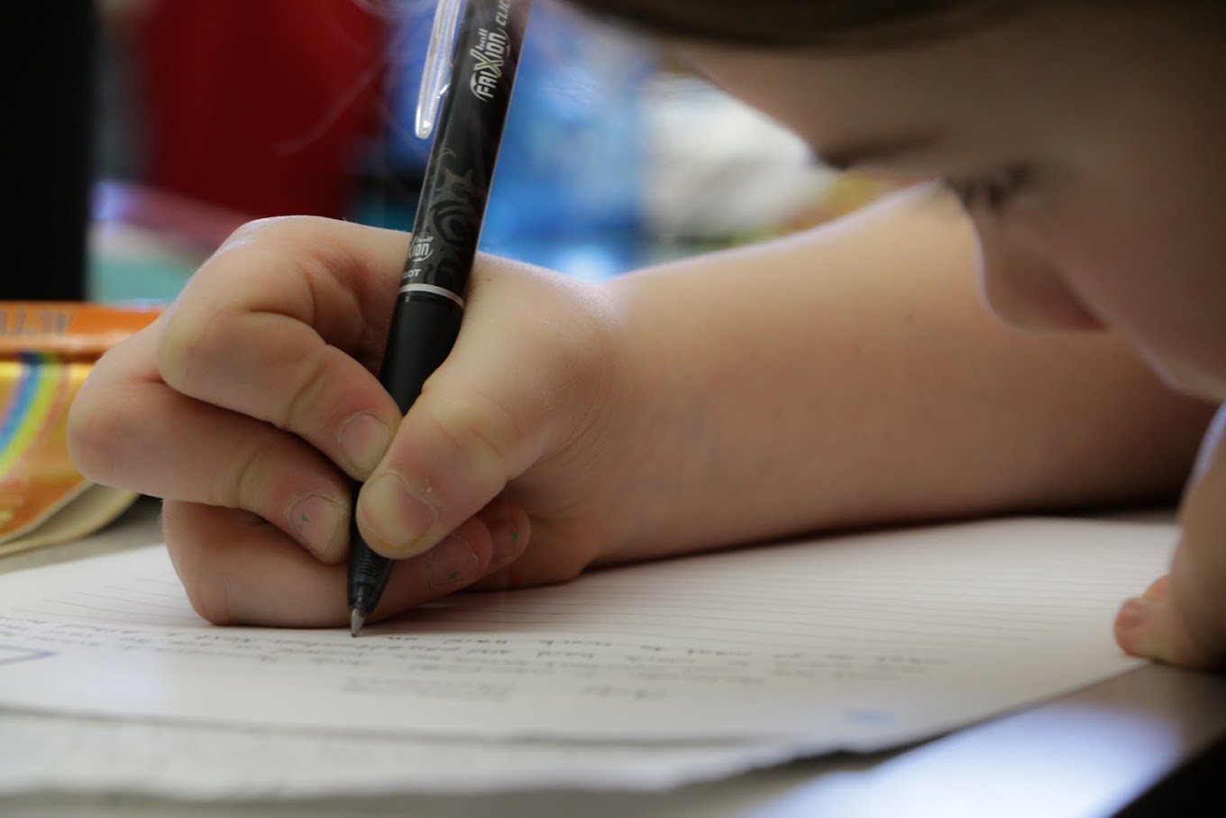 child writing on paper